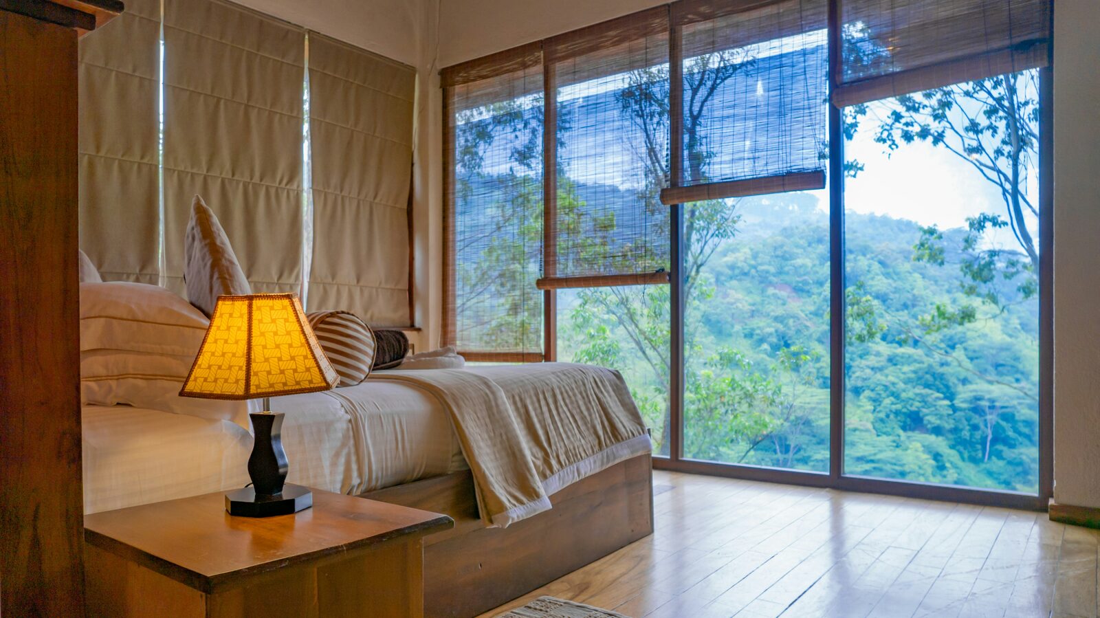 A guest room at a Grackle-managed cottage, with floor-to-ceiling views of the Western Ghats forest