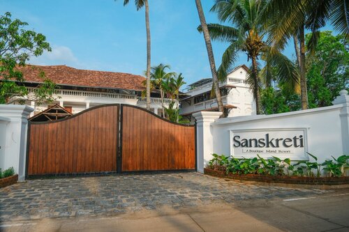 Sanskreti's entrance gate framed by coconut palms